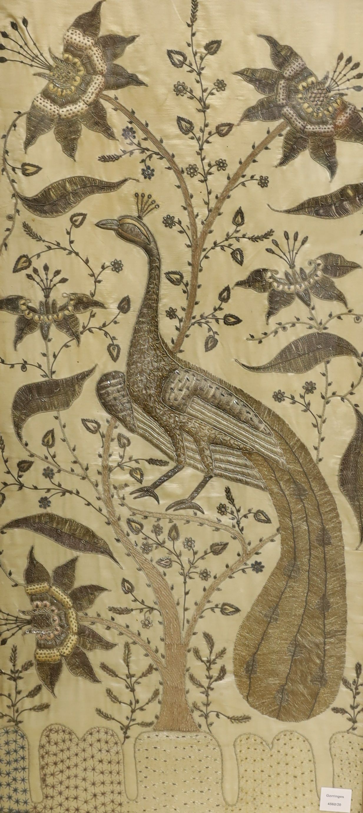 A framed large 19th century Indian embroidered panel decorated with a peacock and flowers 108x49cm